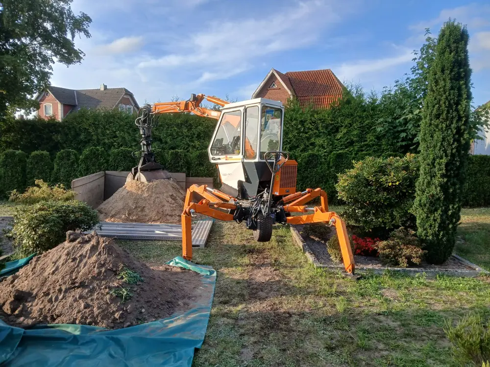 Schreitbagger bei Erdarbeiten in einem Hausgarten