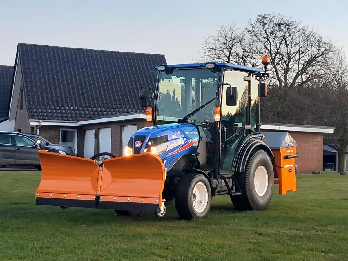 Iseki Traktor mit Schneepflug und Streuer, einsatzbereit für den Winterdienst